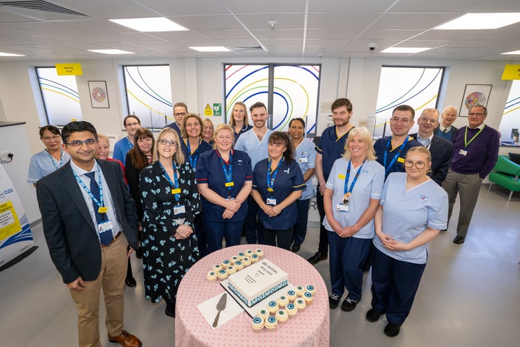 Staff share a celebratory cake for the opening of a new macular treatment centre in Taunton.