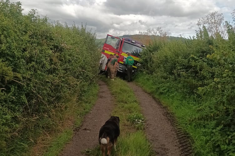 Local farmer Laurence Gay inspects a heavy rescue fire brigade tender stuck in a deep ditch before towing it out with his tractor Funkeswell River Axe light aircraft crash fored landing