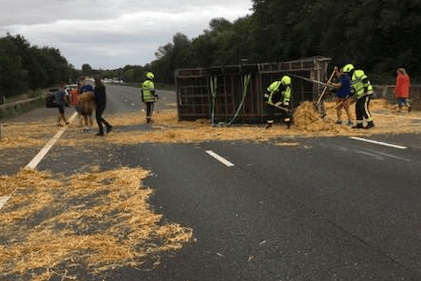 Wellington fire crews help sweep up straw on the M5 near junction 26.