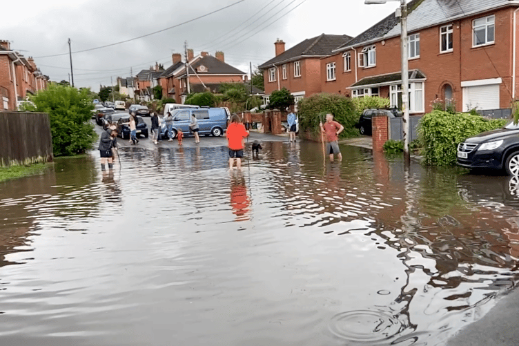 Residents in Seymour Street, Wellington, waded into floodwater to try to unblock drains and free trapped cars.