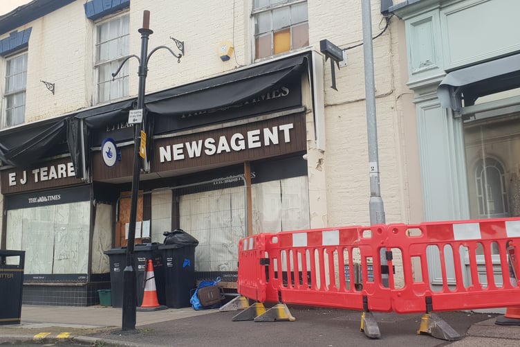 Windows in a poor state of repair can be seen above part of a pavement in South Street, Wellington, which has been cordoned off.