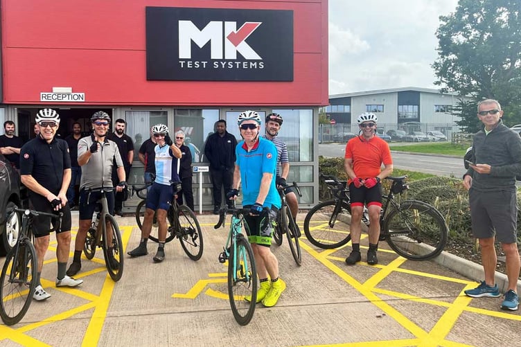 Former MK Test Systems managing director Carl Bullock and fellow charity cyclists stop off at the company in Chelston.