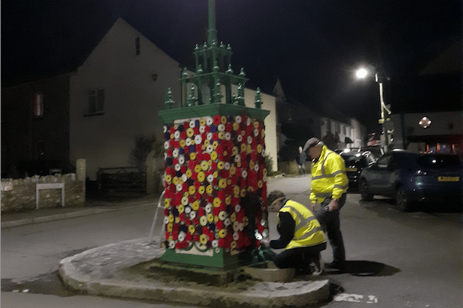 Volunteers decorate Hemyock's listed The Pump with poppies.