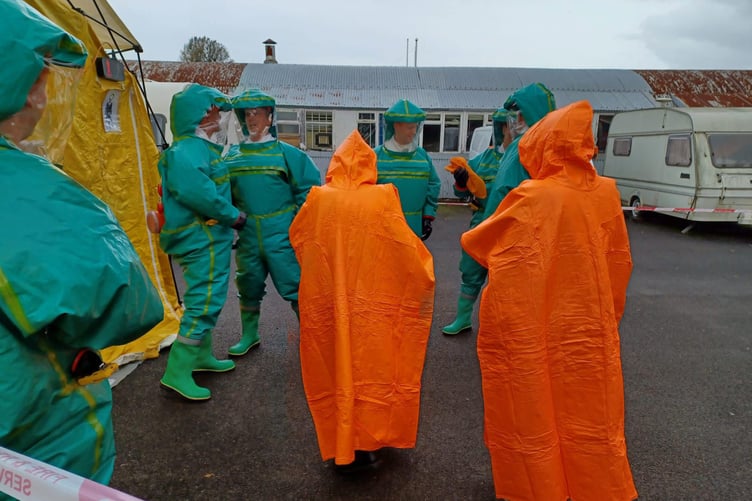 A mass decontamination exercise underway for Wellington firefighters in their green powered respirator protective suits.