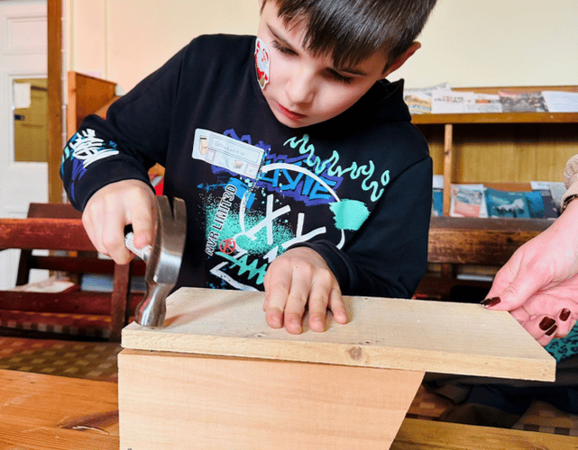 Putting the finishing touches to a bird box during a children's workshop in Wellington.