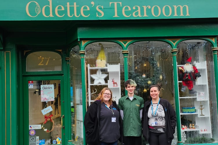 Steph Webber and Dinah Mason present their Christmas jumper day funds to Toby Brimacombe, of Odette's Tearoom.
