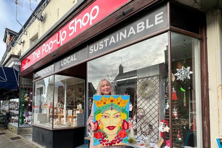 Ms Kaya outside the pop-up shop with one of her artworks.