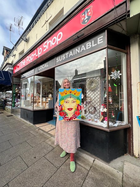 Ms Kaya outside the pop-up shop with one of her artworks.