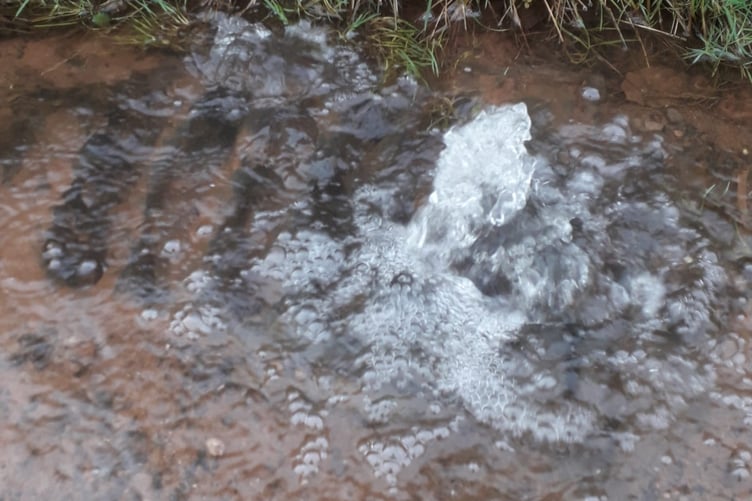 Water is forced out of a blocked roadside drain in Westford, Wellington, on Boxing Day.