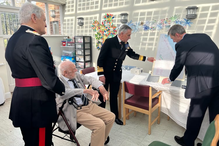 D-Day veteran Richard Willis (seated) is presented with a chart of the Normandy beaches by Hydrographic Office chief executive Rear Admiral Peter Sparkes (right) and Somerset Deputy Lord Lieutenant Rear Admiral Ian Moncrieff, watched by Vice Lord Lieutenant Ted Allen.