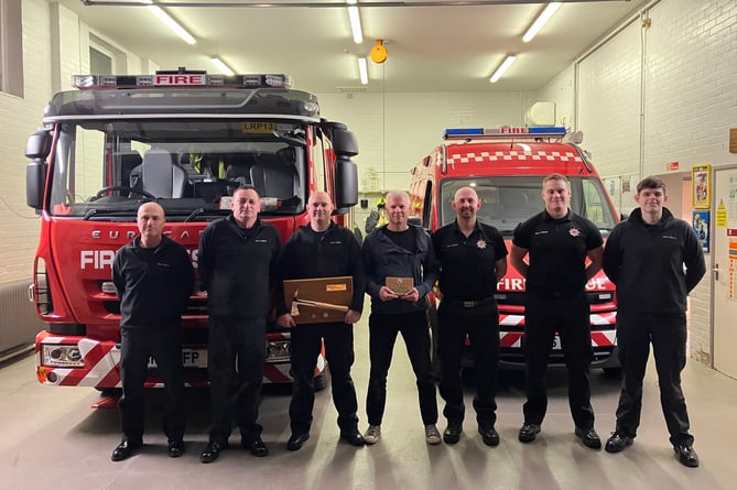 Neil Higgins and Steve Barker (third and fourth, left) with Wiveliscombe firefighters during drill night farewell presentations.