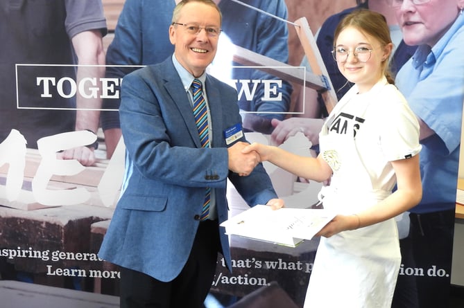 Minehead's Sapphire Haddon receives her young chef award from Rotary district governor Stuart Gilbert.
