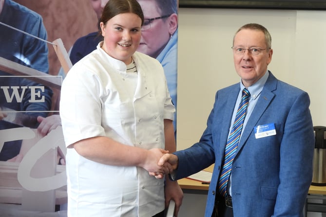 Young chef Katrina Nightingale receiving her award from Rotary district governor Stuart Gilbert.