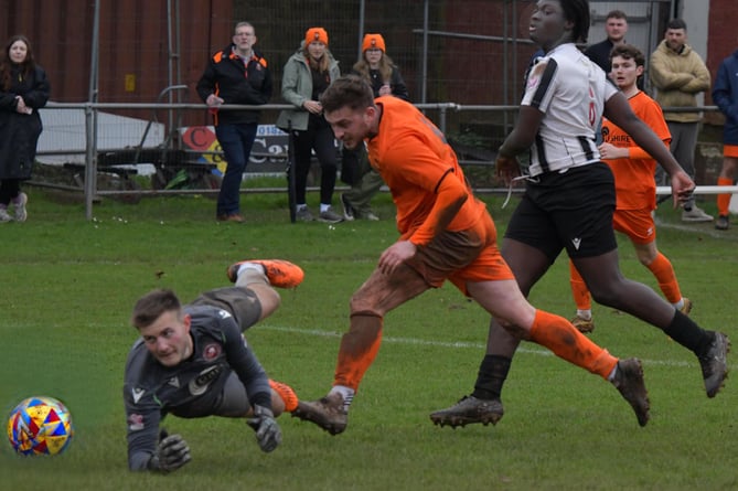 Millbrook goalkeeper Jamie Dudley is helpless as Ryan Brereton puts Wellington ahead in the 3-1 home win in the Premier Division of the Toolstation League at the Playing Field last weekend. (PHOTO: Alan Lockyer)