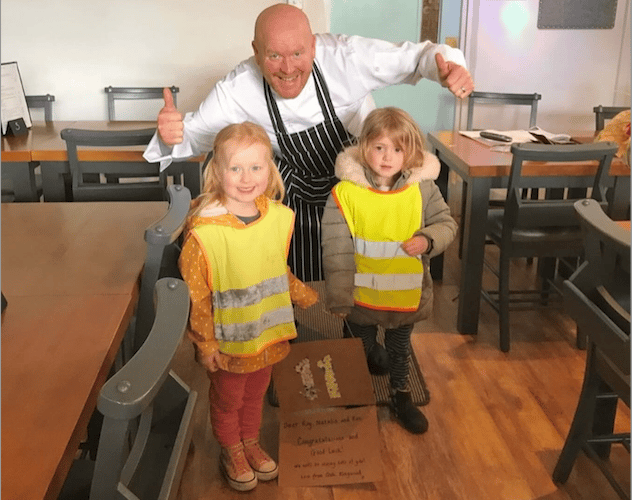 Roy Keeling in Uffculme's Café No 11 with some of the Kingwood Children who presented a welcome card.