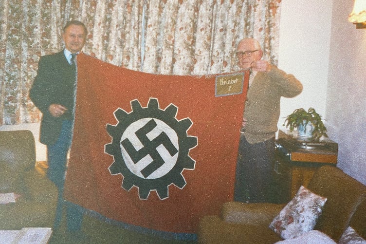 David Hawkings (left) with his cousin Charles, and the Swastika he seized from a German weapons factory during the war