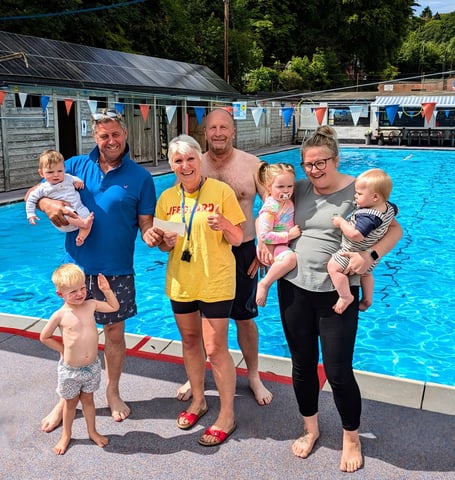 Wivey Pool chairman Liz Hurry (centre) receives a £1,000 cheque from (left to right) Riley and Kit Kennett, Martin Greenway, Chris Briggs, Darcie, Oscar, and Charmaine Veryard.