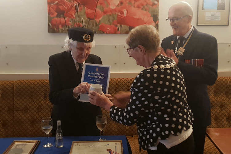 Madge Covey with her RBL centenarian membership receiving a specially-designed mug from Wellington Mayor Cllr Janet Lloyd watched by legion county president Cmdre Bob Mansergh.