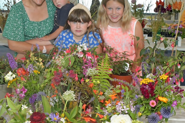THE AVERY FAMILY LOOK OVER ONE OF THE FLOWER DISPLAY EXIBITS