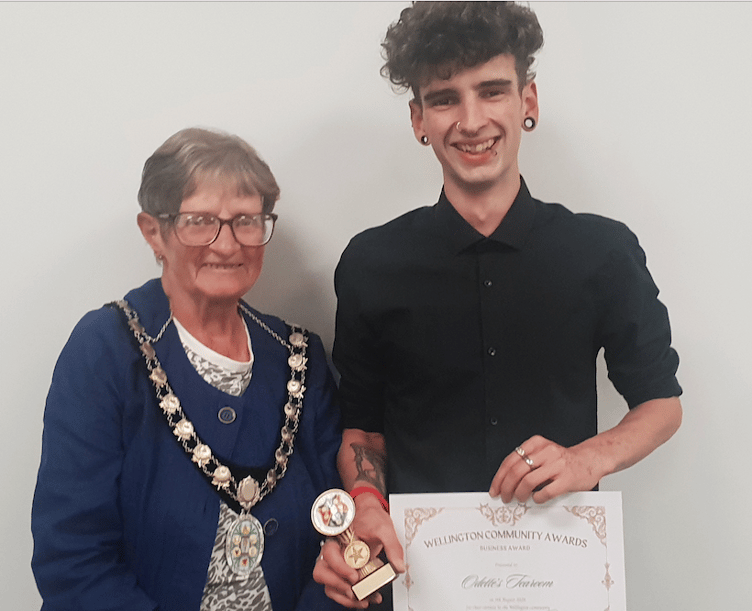 Wellington Mayor Cllr Janet Lloyd presenting Toby Brimacombe, of Odette's Tearoom, with the town council's 2024 business award.