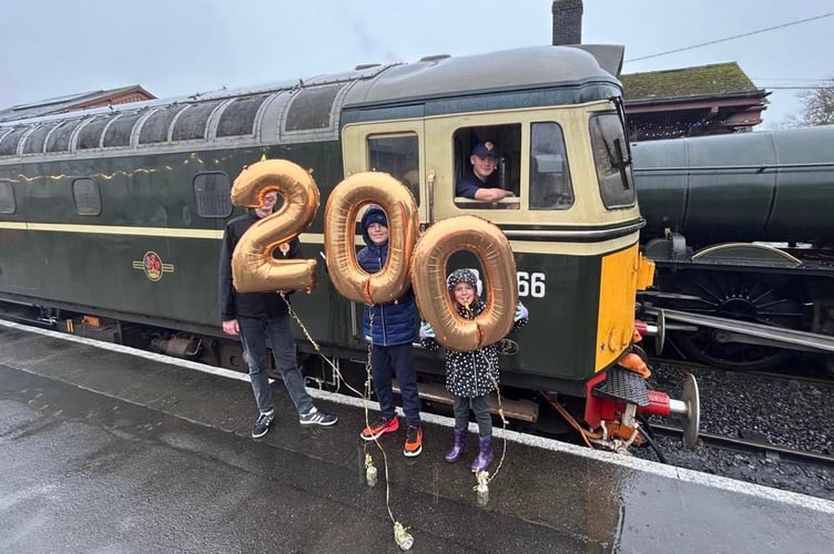 Elliott Freegard, West Somerset Railway's youngest volunteer joins the Whistle Up to celebrate. Elliott's siblings hold the '00' balloons and another WSR volunteer joins, holding the '2'.