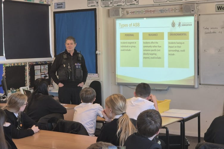 Local police officers deliver a workshop on community safety and understanding anti-social behaviour to Year 8 students - court fields school