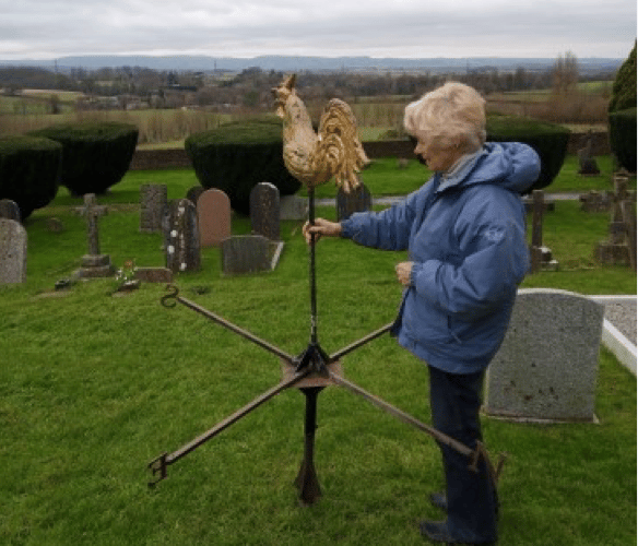 The Vicar of Langford Budville, the Rev Helene Stainer, with the parish church's fallen cockerel weather vane.