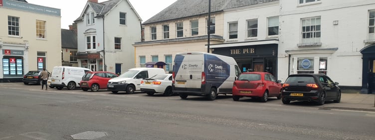 Nine vehicles (one partly hidden) parked in three official designated near the old Post Office in High Street, Wellington.