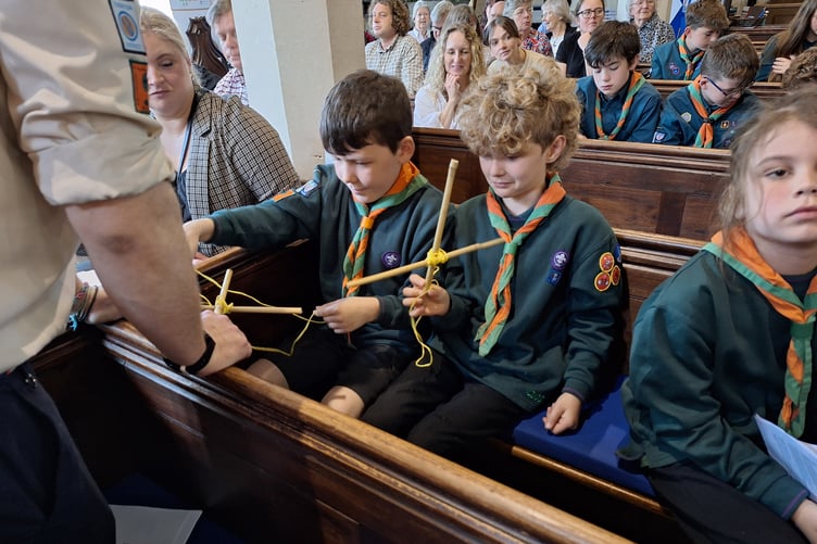 Members of Hemyock Scout Group try their hands at rope lashing during a St George's Day church service.