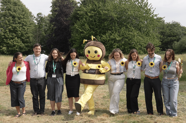 Staff and mascot Busy Bee celebrate a fund-raising success for St Margaret's Hospice.