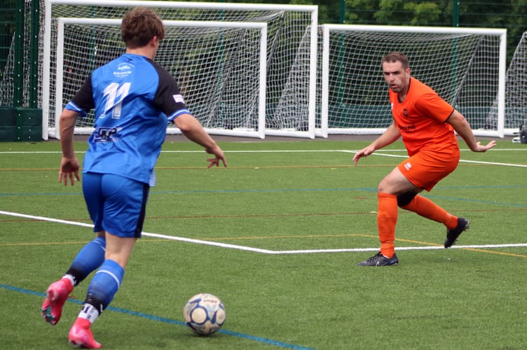 Defender Mark Cornish (tangerine) in action for Wellington against Brixham
