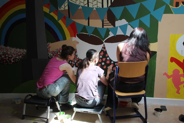 Year 9 students from Court Fields School hard at work creating the new vibrant mural in the King's Arms Community Hub