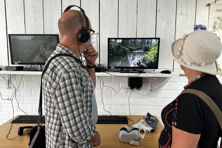Visitors watch a video at the Pop-Up Shop for the Water Guardian's week of events