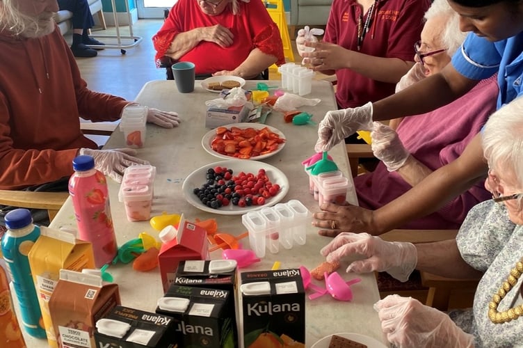 Preparing fruit ice lollies at Camelot House