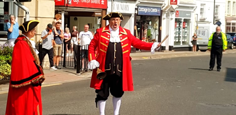 Wellington town crier Andrew Norris reads a VJ Day proclamation at noon in the town centre.