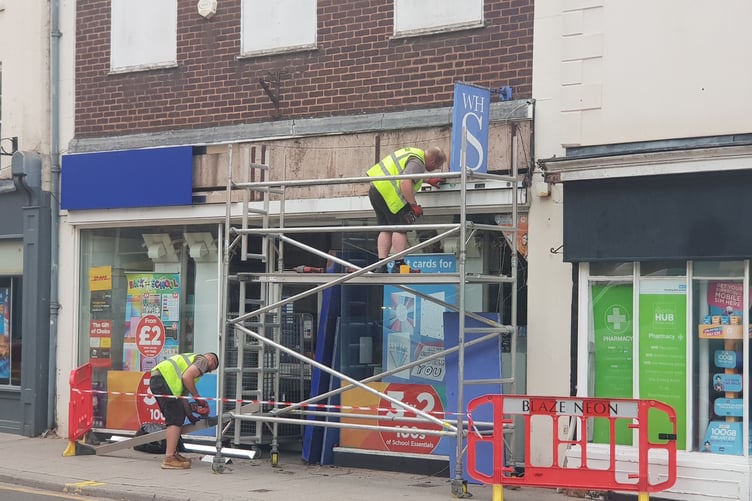 Contractors remove the WH Smith signage from the front of the company's Wellington store.