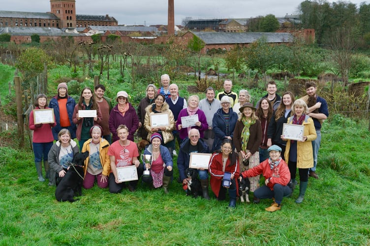 Supporters and volunteers of Transition Town Wellington standing in Fox’s Field Forest Garden along with the RHS Award