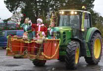Father Christmas arrives by tractor at farm shop