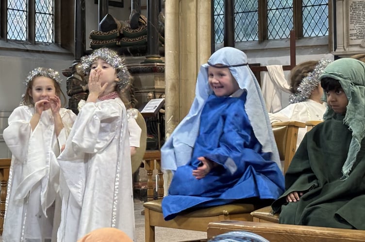 Angels and shepherds shining in front of the crowd.