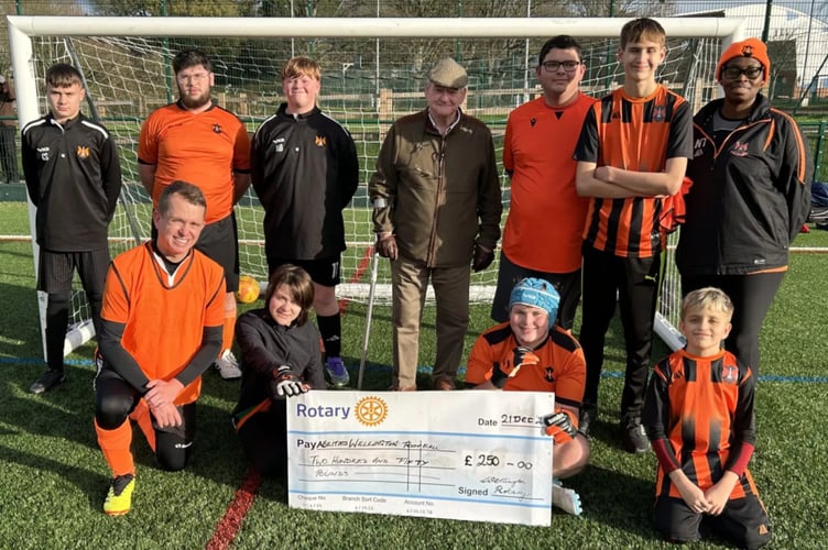 Richard Williams, president of the Rotary Club of Wellington, presents a cheque at a training session