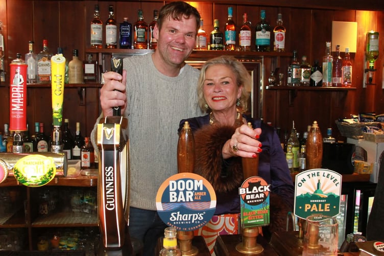 MP Rachel Gilmour pulls a pint with Nick Moores, whose family has reopened the Butchers Arms pub, in Carhampton.