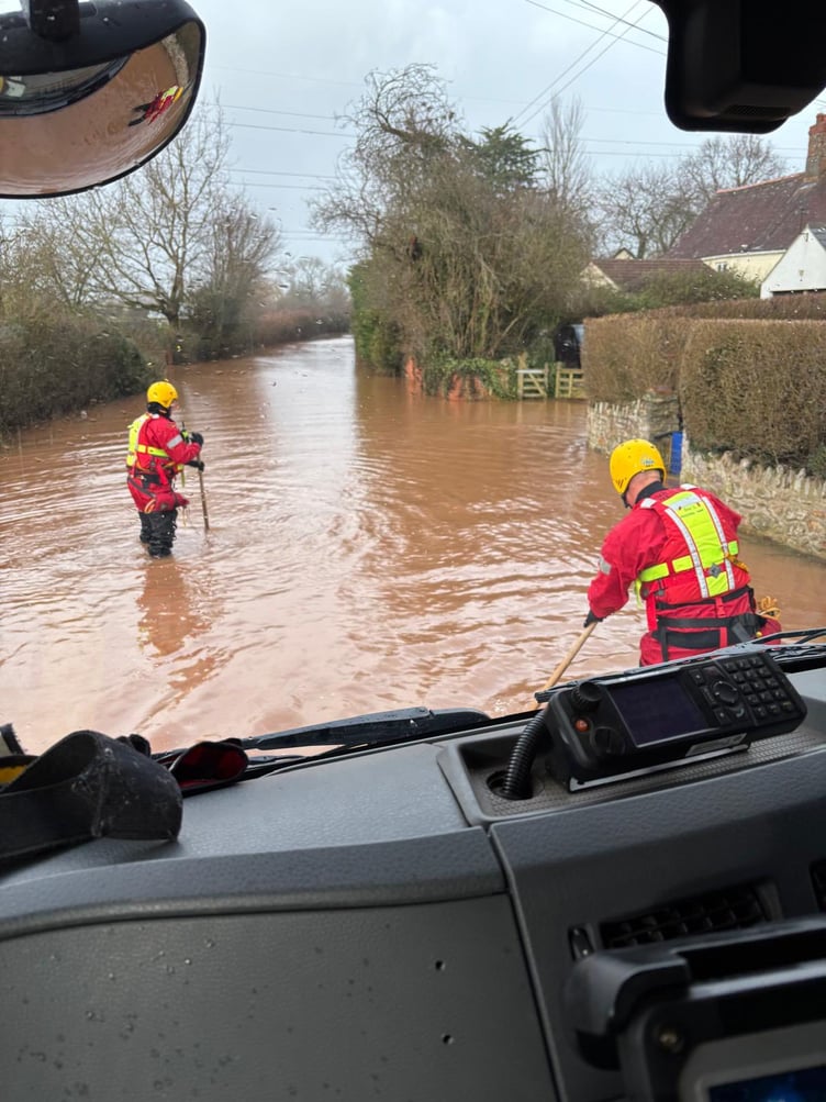 Firefighters probe a flooded rural road as they respond to an emergency call on Tuesday.