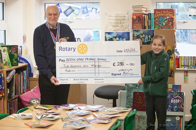 Rotary Club of Wellington secretary Miles Halliwell presents a cheque for £250 to Beech Grove School.