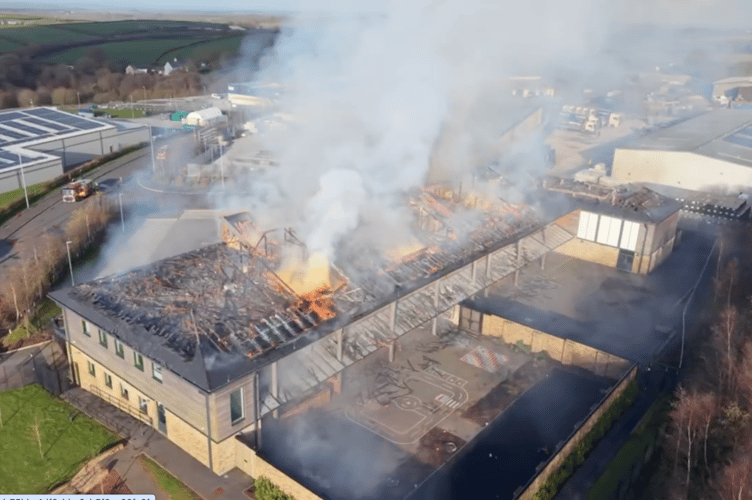 Drone footage shows flames erupting from the roof of the school.