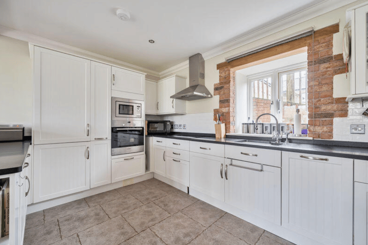 The kitchen is fitted with a comprehensive range of wall and base units (Picture: Wilkie May & Tuckwood)