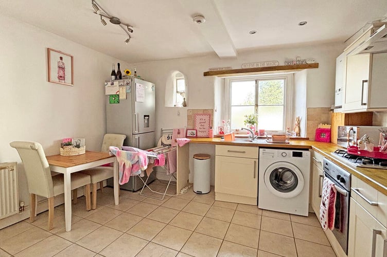 The kitchen is fitted with a comprehensive range of modern wall and base units