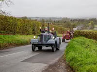 Vintage tractors parade through scenic countryside