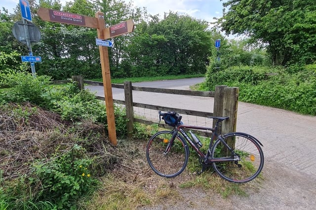 Mike Ginger's bike propped up next to a fingerpost on the Strawberry Line.