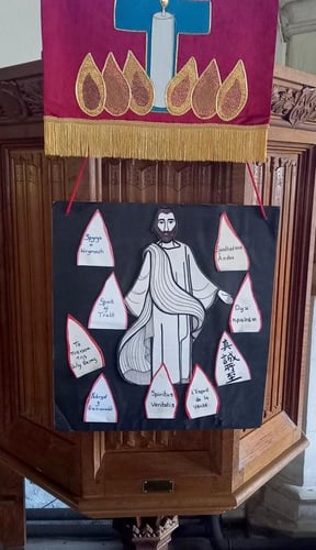 A banner depicting Christ and how his disciples found they could be understood in many languages at the first Pentecost.