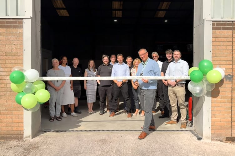 Sedgemoor Chamber of Commerce general manager Roger Smith cuts a ribbon to declare open a new manufacturing unit for PRM Waste Systems on Wellington's Lowmoor business park.